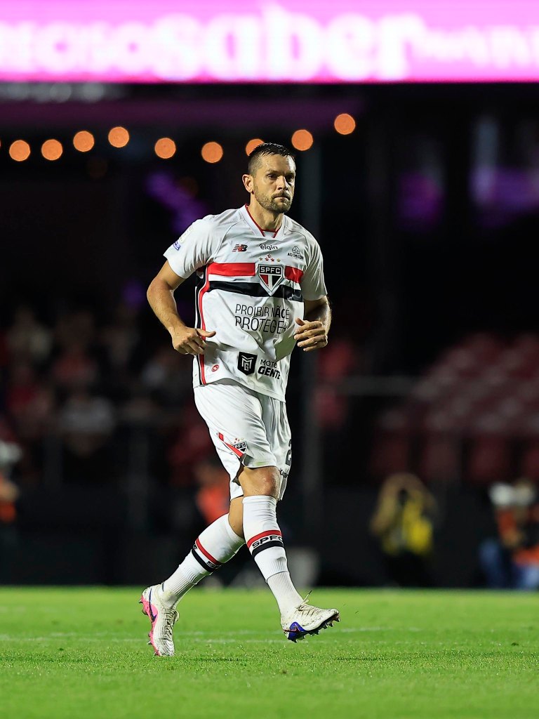 Escalação de Toloi vira polêmica e Dorival Junior explica escolha no São Paulo 1 Jogador de futebol em campo, vestindo uniforme do São Paulo FC, com foco em sua expressão enquanto caminha.